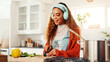 © FlexOn/peopleimages.com - Cooking, cutting and headphones with woman in kitchen of home for health, organic diet or nutrition. Knife, music and streaming with person at counter in apartment for culinary food preparation