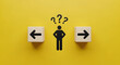 © creative - Decision making and choosing the right path. Confusion about deciding which direction to go. Stickman with question marks standing in between the wooden cubes with arrow symbols.