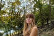 © Cavan Images - Woman smiling softly in a sunlit forest setting