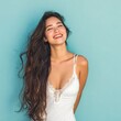 © Surachetsh - a woman with long dark hair standing against a light blue background. Her white top and even lighting make the details of her face and hair easy to see.
