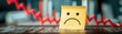 © pingpao - A sad face on a sticky note represents negative emotions, set against a backdrop of declining charts, symbolizing poor performance or loss.