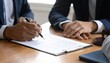© Nasra - Man signs legal document, another watches. Gavel present