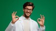 © maxximmm - In a vibrant green background, a young man in a white coat confidently makes an 'OK' gesture with both hands, reflecting positivity and professionalism. The man's gesture underline