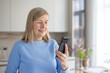 © Liubomir - Senior woman smiling while holding and using a smartphone for a video call, communicating with family or friends and staying connected through technology