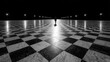 © Natthakan - A solitary figure walks on a striking checkerboard path at night.