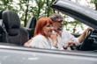 © standret - View from the side. Senior couple driving convertible cabriolet car