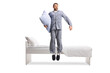 © Ljupco Smokovski - Man in pajamas holding a pillow and jumping from a bed
