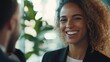 © lertputhai - Smiling woman in professional attire engaged in conversation in bright office environment