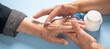 © andranik123 - Woman applying cream to elderly female hands.