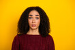 © deagreez - Young mixed race woman with curly hair wearing a red sweater stands against a yellow background with a surprised expression