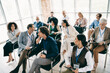 © deagreez - Diverse group of professionals engaging in a corporate meeting inside a spacious modern office, fostering teamwork and collaboration.