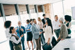 © deagreez - Group of professional coworkers engaged in a discussion in a well-lit modern office space emphasizing teamwork and collaboration