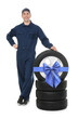 © New Africa - Tire service worker, car wheel and tires on white background. Special offer or discount
