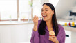 © Home-stock - Attractive woman with tasty ice cream in kitchen, lady enjoy having cheat meal time and eating sweet dessert, space for text