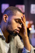 © DC Studio - Concerned african american man struggling with task deadlines and work pressure, being stressed and worried about his future. Frustrated scared person working remotely on the couch.