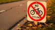 © Herman - A Prohibited Cycling Sign On Roadway With Autumnal Foliage And Gravel Surface
