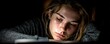 © Tin - Exhausted student slumped over laptop desk concept. A young woman deeply focused on reading in low light.