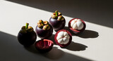 Fresh ripe purple mangosteen fruits whole and sliced open.