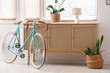 © Pixel-Shot - Modern bicycle near chest of drawers in light room