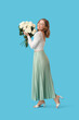 © Pixel-Shot - Beautiful happy young woman with bouquet of white roses on blue background
