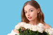© Pixel-Shot - Beautiful young woman with bouquet of white roses on blue background