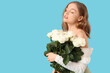 © Pixel-Shot - Beautiful young woman with bouquet of white roses on blue background