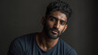 © Lara - Young man with curly hair looking slightly serious in dark setting