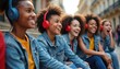© Vadym - Teenagers wearing headphones sit outside. Group of happy young friends listen to music. Women laugh and smile. Teens have fun together outdoors in city.