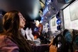 © Westend61 - Smiling woman enjoying arcade racing video game indoors