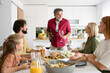 © Westend61 - Grandfather talking at family dinner celebration in a home kitchen