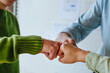 © Westend61 - Colleagues celebrating teamwork victory with a fist bump in office