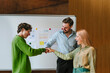 © Westend61 - Colleagues celebrating success together at office meeting