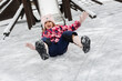 © Studio Peace - Child sliding down icy playground slide. Happy kid playing outdoors in cold weather