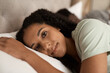 © mavoimages - Smiling young woman lying in bed with her husband
