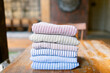 © Danial - Freshly laundered striped towels stacked neatly on a rustic wooden table, perfect for cozy interiors, bath accessories, or textile advertisements showcasing simple elegance