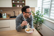 © Migma_Agency - Happy man eating healthy breakfast in kitchen