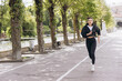 © anatoliycherkas - Athletic woman running on path in park