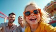 © Viktor - Family enjoys amusement park ride together. Daughter with sunglasses laughs joyfully, parents smile behind. Carousel and roller coaster are visible. Sunny day out.