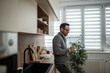 © Migma_Agency - Man drinking coffee in modern kitchen at home