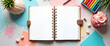 © GG Kenji - An inviting flat lay of a planner open on a desk, surrounded by vivid markers and inspirational elements, provides great space for text and graphics.
