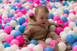 © splitov27 - Cute little baby plays in a dry pool with balls at a children's entertainment center