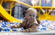 © splitov27 - Cute little baby plays in a dry pool with balls at a children's entertainment center