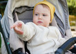 © splitov27 - Little cute baby in a hat sits in a stroller outdoors