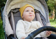 © splitov27 - Little cute baby in a hat sits in a stroller outdoors