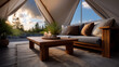 © Oatkhaphon - Tent setup for glamping with cozy wooden table and sofa inside luxury canvas shelter at sunset