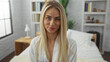 © Krakenimages.com - Woman with visible face smiling while wearing white robe on bed in bedroom; serenity comfort relaxation intimacy.