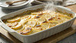 © MstTamannahar - A steaming dish of scalloped potatoes, baked to golden perfection, sits on a wooden board, showcasing the creamy, comforting texture of this classic side dish