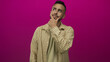 © Krakenimages.com - Young hispanic man touching chin and pointing finger in studio with magenta wall; thoughtful reflection.