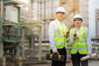 © Nutchapong Wuttisak - Male and female engineers wearing reflective vests, blueprints, toolboxes develop modular energy solutions at the power plant industrial, aiming to lead the global market in electricity exports