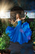 © Miramiska - A beautiful woman in a flowing blue gown gracefully dances indoors, illuminated by warm sunlight. The scene evokes joy and movement.